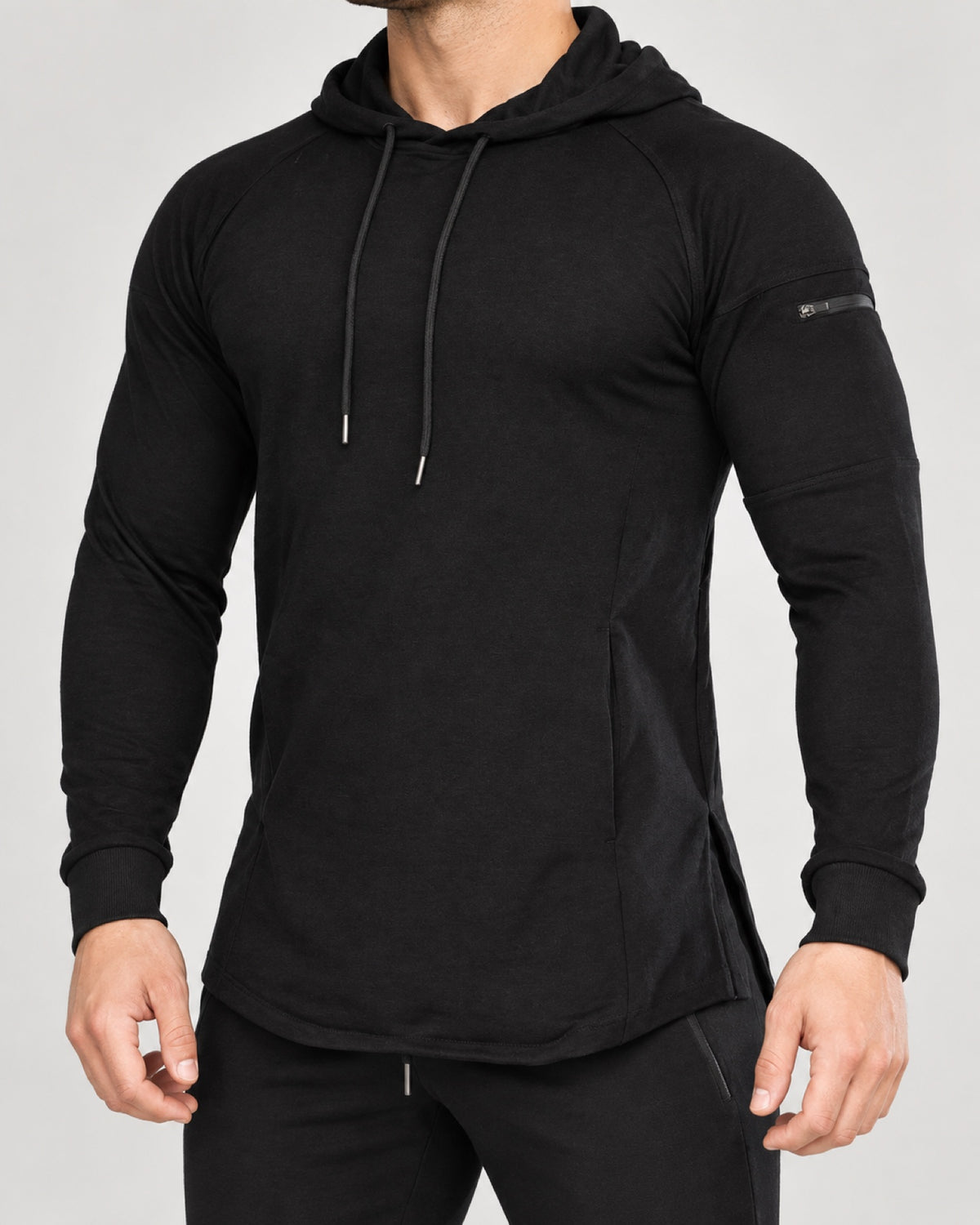 Bounty Sleeve-Pocket Hoodie in Black — front studio view showing the sleeve zip pocket and curved hem.