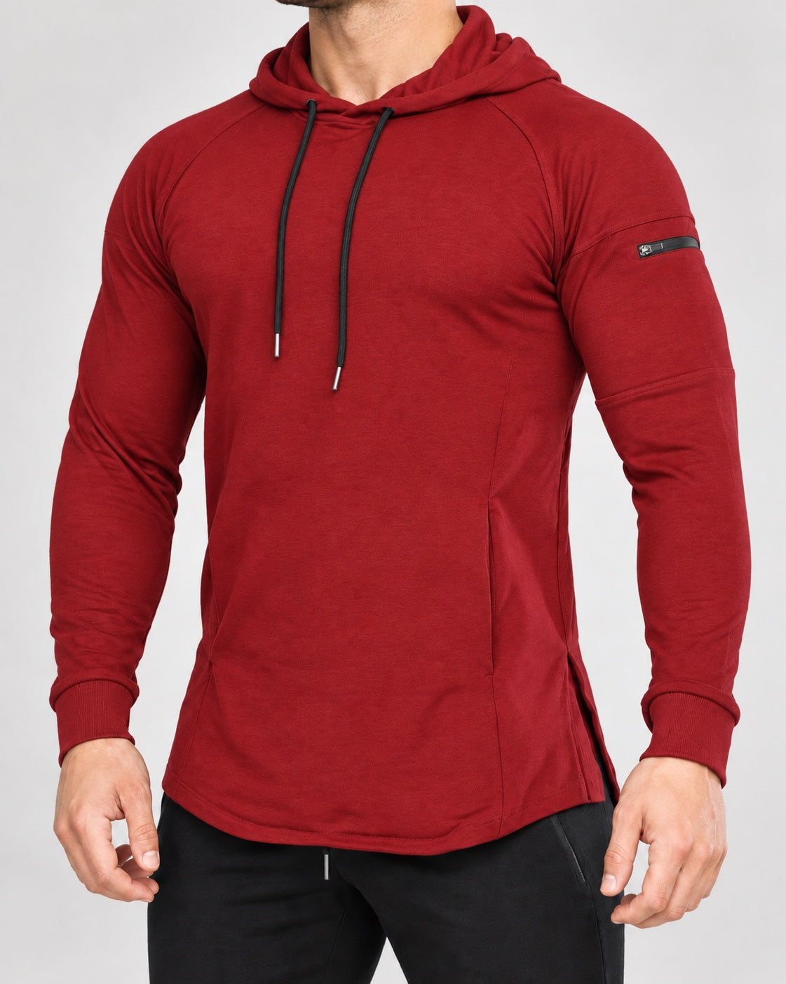 Bounty Sleeve-Pocket Hoodie in Red — front studio view showing the sleeve zip pocket and curved hem.
